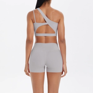 Detail view of one-shoulder yoga bra with asymmetric back cutout and high-waist shorts