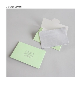 Detailed view of silver polishing cloth and green envelope for jewelry care