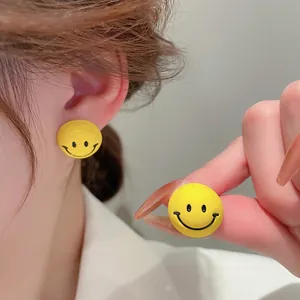 Cute yellow cartoon smiley face stud earrings with a matte finish for women