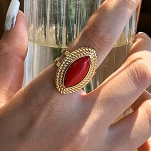 Close-up of red gemstone ring with vintage gold setting worn on a finger