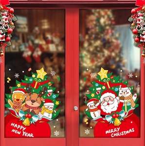 Dettaglio di adesivi natalizi statici con Babbo Natale e renne su una porta di vetro