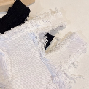Nahaufnahme von Jeansstoff mit schweren Fransenrändern und Twill-Textur-Details