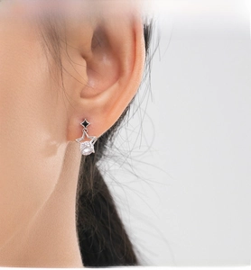 Detail of S925 silver hollow star earrings with zircon and black diamond enamel on model