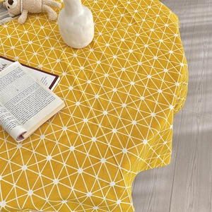 Close-up of yellow cotton linen tablecloth featuring white geometric triangle patterns