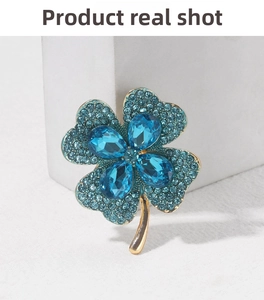 Macro shot of gold-plated clover brooch with sparkling blue crystals and rhinestones