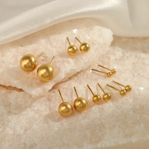 Minimalist golden stainless steel ball stud earring set in various sizes on white crystals
