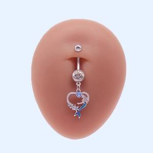 Vue détaillée d'un piercing nombril sirène en forme de cœur avec cristaux bleus