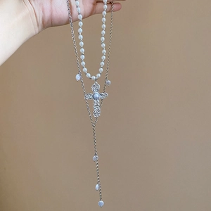 Vue détaillée du collier double couche avec pendentif croix et perles baroques