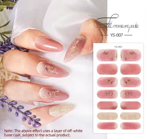 Detail of pink gradient flower nail wraps with gold foil and glitter on white silk