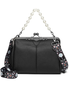 Detail of black PU leather handbag with pearl handle and ethnic pattern strap