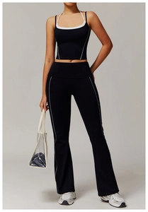 Détail d'un ensemble de sport noir avec surpiqûres blanches contrastées et pantalon évasé
