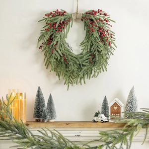 Heart shaped Christmas wreath with green pine needles and red berries for home decor