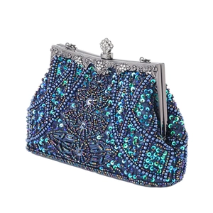 Dettaglio ravvicinato di ricami in perline blu e viola su una borsa da sera vintage