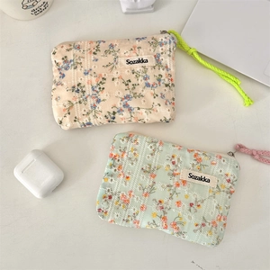 Close-up of floral print fabric cosmetic bags with zippers and embroidered details
