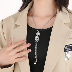 Detail view of silver tassel necklace with geometric square zircon pendants on a model