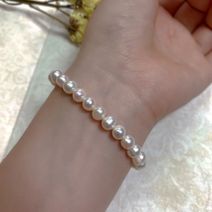 Detailed view of natural baroque pearl bracelet with 14K gold clasp on woman's wrist