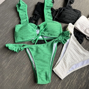 Three-piece bikini set with ruffles and waffle texture in neon green black and white