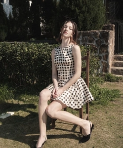 Detail of black and white plaid sleeveless dress with decorative buttons on front