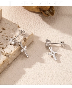 Macro view of sterling silver cross earrings with round cut sparkling crystals