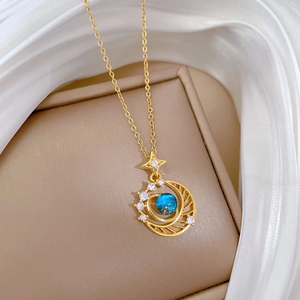 Titanium steel moon and star necklace with blue sphere gemstone on silk fabric
