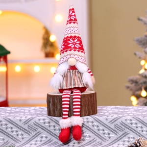 Close-up of a Christmas gnome featuring a red knitted snowflake hat and long striped legs