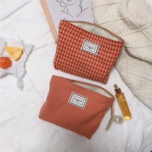 Detail of orange checkered canvas pouches with metal zippers and fabric labels