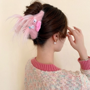 Close-up of pink plush monster hair claw clip worn by a model for a creative hairstyle