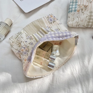 Macro detail of floral quilted makeup bag with lace trim and soft cotton texture