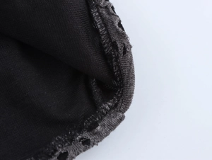 Gros plan sur la maille noire et les poignets élastiques côtelés d'un t-shirt manches longues