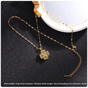 Detail view of gold clover pendant with green zircon inlay and titanium steel chain