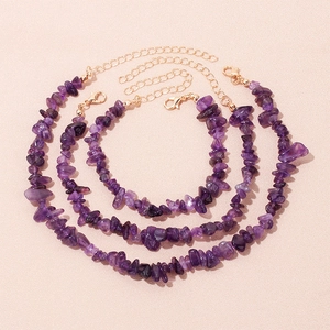 Detailed view of three natural purple amethyst bracelets with golden lobster clasps