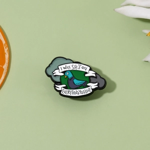 Funny pigeon enamel pin with I WILL SHIT ON EVERYTHING YOU LOVE text on green background