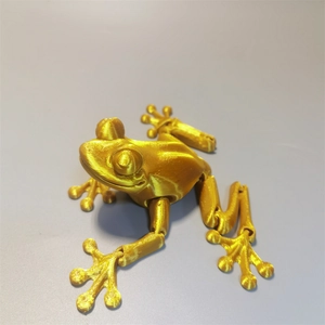 Top-down view of a golden 3D printed frog with movable joints and metallic PLA texture