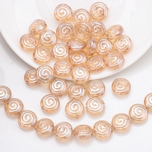 Detailed macro view of champagne gold spiral patterned round glass beads for DIY jewelry