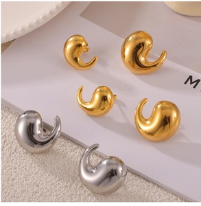 Macro shot of polished gold and silver water-drop earrings with mirror finish