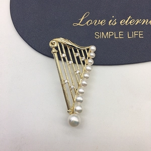 Golden harp brooch with natural freshwater pearls and sparkling crystals on card
