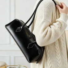 Detail of contrast white stitching on black leather bowling bag with long shoulder straps
