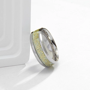 Detailed close-up of an 8mm titanium ring with luminous green base and gold dragon pattern