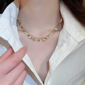 Close-up of double-layer gold geometric sequin choker on a model wearing white shirt