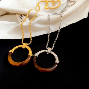 Dettaglio della collana con pendente geometrico in resina oro e argento con catena box