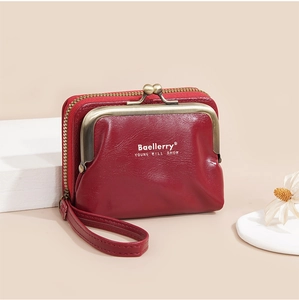 Detail of red leather mini wallet with litchi pattern, metal clasp and wrist strap