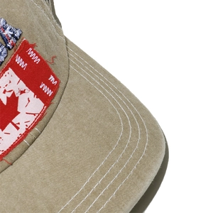 Close-up of khaki cotton baseball cap brim with stitching and vintage patches