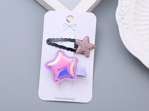 Close-up of sparkling star hair clips for girls in iridescent pink on display card