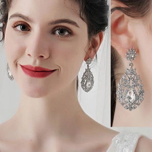 Detail of silver drop earrings with white rhinestones on model for bridal style