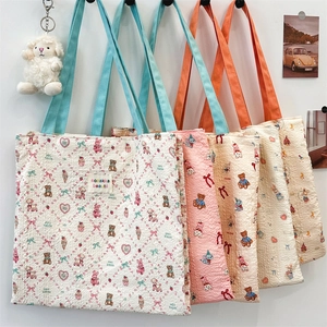 Detail of seersucker tote bags with cartoon patterns and textured fabric surface