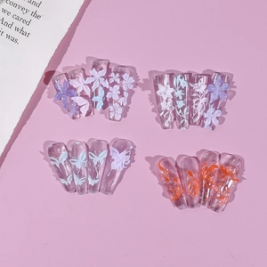 Detail of 3D embossed floral and goldfish designs on transparent pink press-on nails