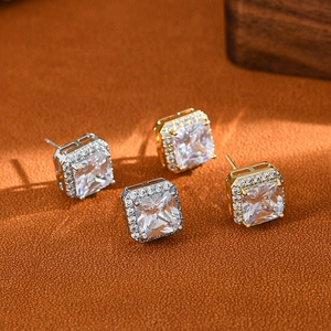 Macro shot of silver and gold geometric square halo stud earrings with cubic zirconia
