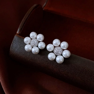 French vintage flower pearl earrings with zircon centers on a luxury leather jewelry box