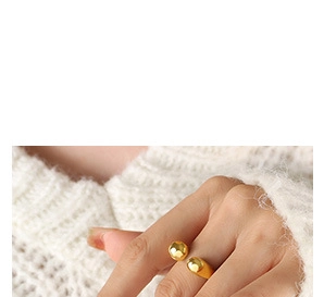 Detailed view of an adjustable gold-plated ring with faceted bead on a model's finger
