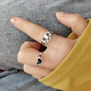 Close-up of silver heart rings with engraved Chinese text worn on a model's hand